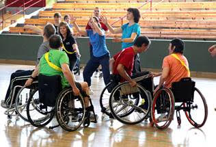 Rollstuhlfahrende und zweibeinig laufende Menschen treiben gemeinsam Sport.